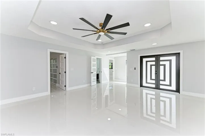 Spare room with a raised ceiling, recessed lighting, french doors, and a ceiling fan