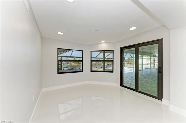 Spare room with recessed lighting, a sunroom, and a water view