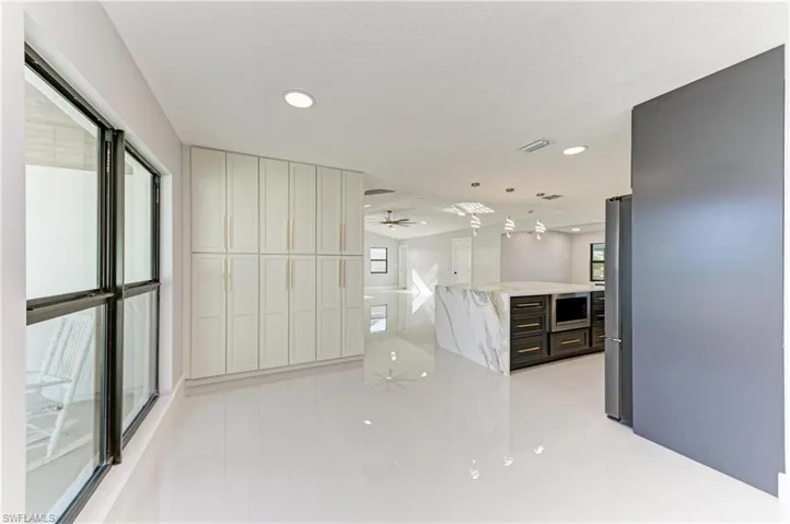 Kitchen with pendant lighting, recessed lighting, light stone counters, appliances with stainless steel finishes, and a ceiling fan