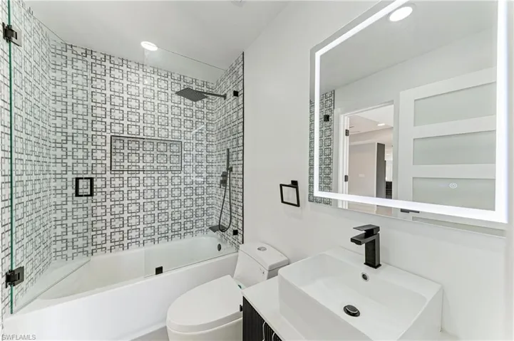 Bathroom featuring vanity, shower / washtub combination, and recessed lighting