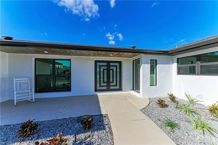 Property entrance featuring stucco siding and a porch