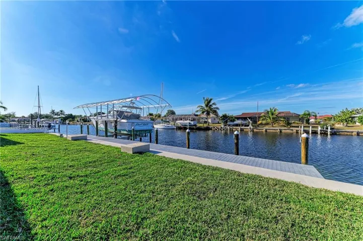 Dock area with a lawn, a water view, and boat lift