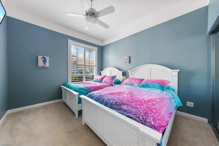 Bedroom with a ceiling fan, a closet, light carpet, and baseboards