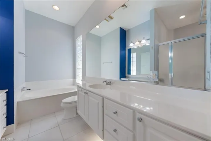 Bathroom with plenty of natural light, tile patterned floors, and vanity