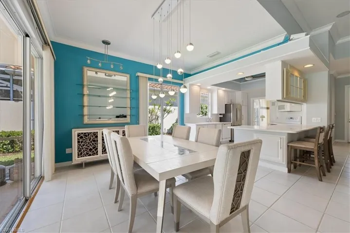 Dining space featuring light tile patterned floors, ornamental molding, and visible vents