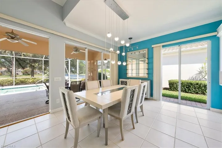 Dining space with tile patterned floors, plenty of natural light, crown molding, and ceiling fan