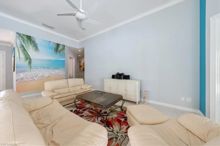 Living room featuring visible vents, tile patterned flooring, and ornamental molding