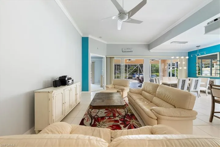 Living area featuring a healthy amount of sunlight, ceiling fan, ornamental molding, and light tile patterned floors