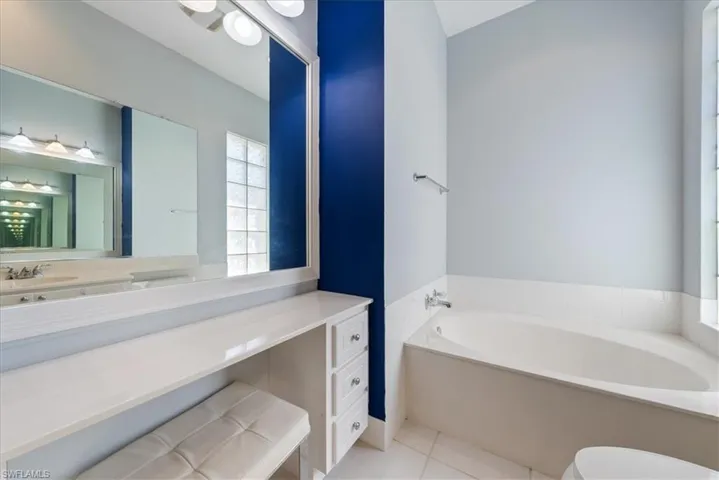 Bathroom with a bath, toilet, tile patterned floors, and vanity