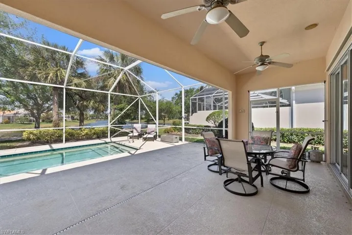 Pool featuring a ceiling fan, glass enclosure, and a patio