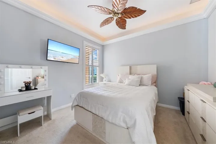 Bedroom featuring baseboards, crown molding, and light colored carpet