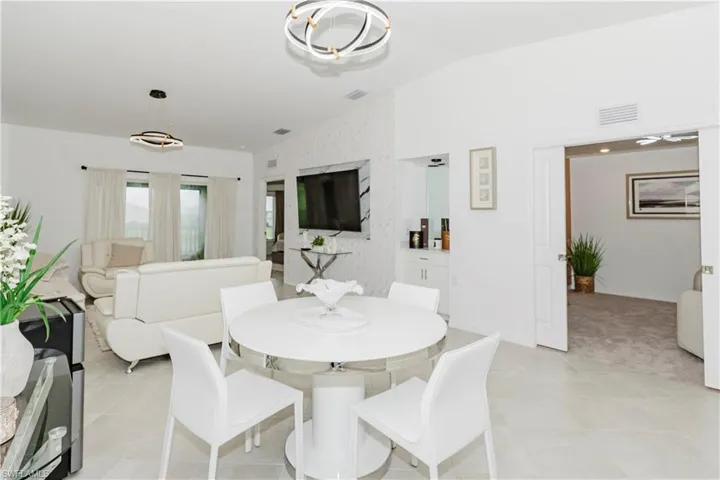 Dining space with lofted ceiling, an accent wall, and baseboards