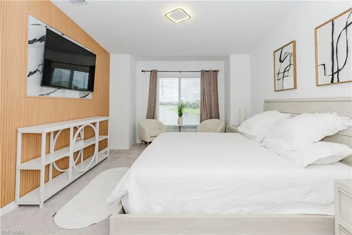 Bedroom with carpet, wooden walls, and baseboards