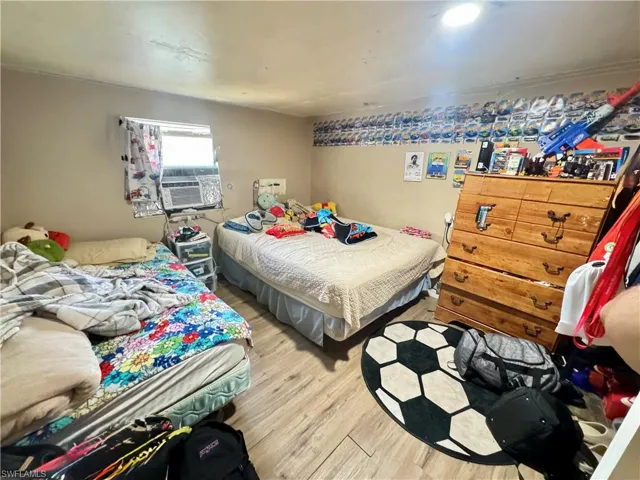 Bedroom featuring light wood finished floors and cooling unit