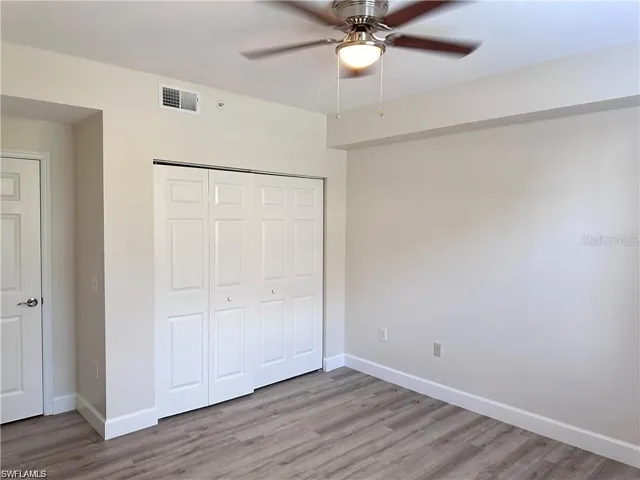 Unfurnished bedroom featuring light wood-style flooring, a closet, and a ceiling fan