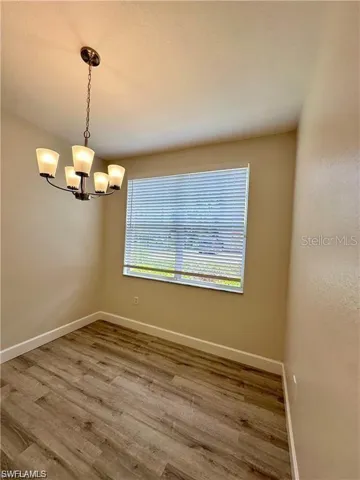 Spare room featuring light wood-style flooring and a chandelier
