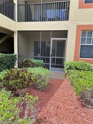 Property entrance with a sunroom and stucco siding