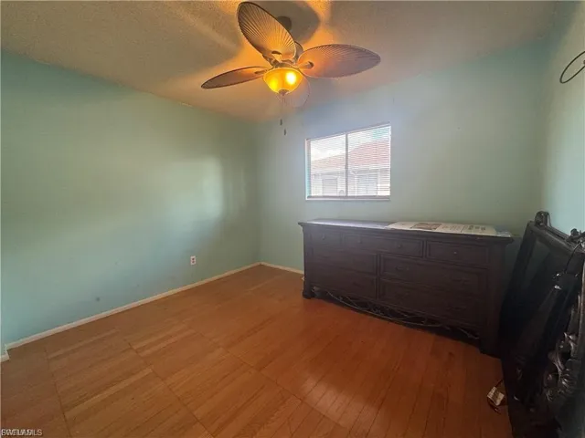 Unfurnished bedroom with ceiling fan and a textured ceiling