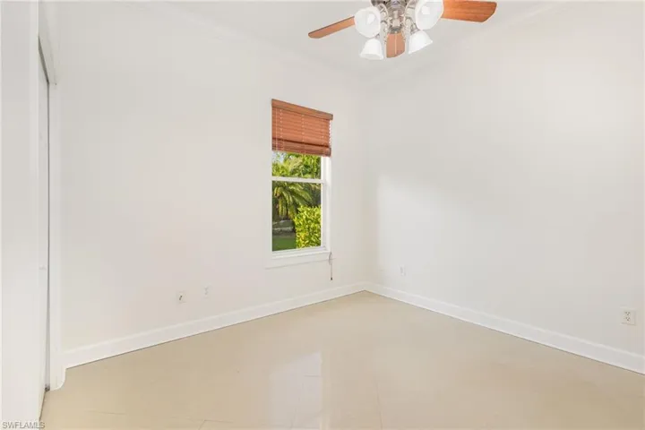 Empty room featuring crown molding and ceiling fan