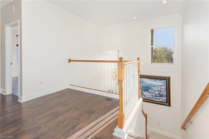 Stairs with ornamental molding, wood finished floors, and recessed lighting