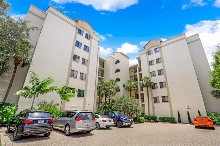 View of apartment building / complex featuring uncovered parking