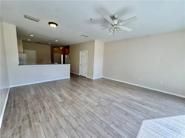 Unfurnished living room with light wood-style floors and ceiling fan