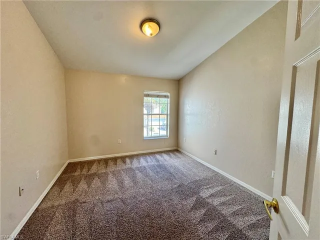 Spare room with carpet floors and a textured wall
