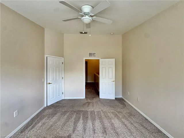 Unfurnished bedroom featuring carpet, a high ceiling, and ceiling fan