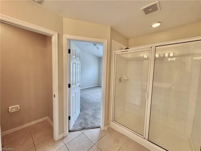 Full bathroom featuring a shower stall, light tile patterned floors, light colored carpet, and recessed lighting