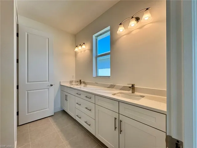 Bathroom featuring tile patterned flooring, a sink, and double vanity