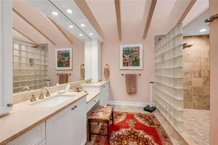 Bathroom featuring a walk in shower, beamed ceiling, vanity, and recessed lighting