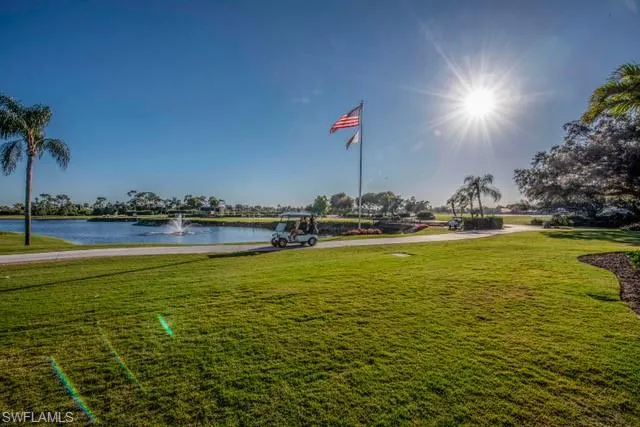 Surrounding community featuring a water view and a lawn