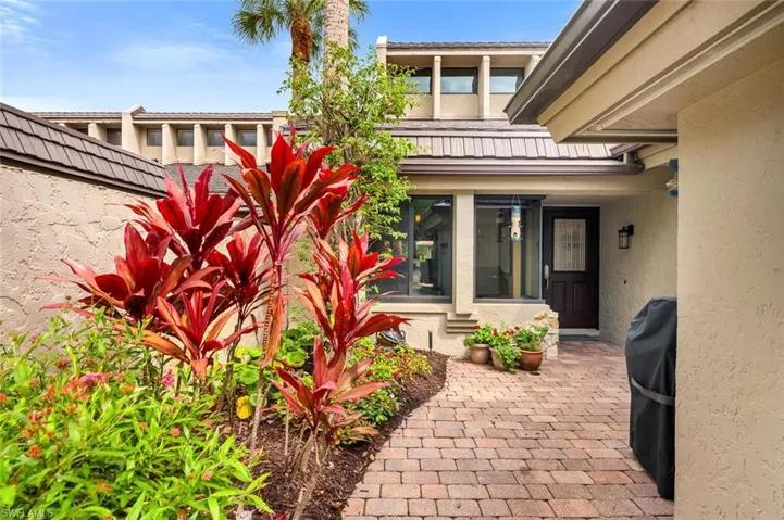 Entrance to property featuring fence and stucco siding