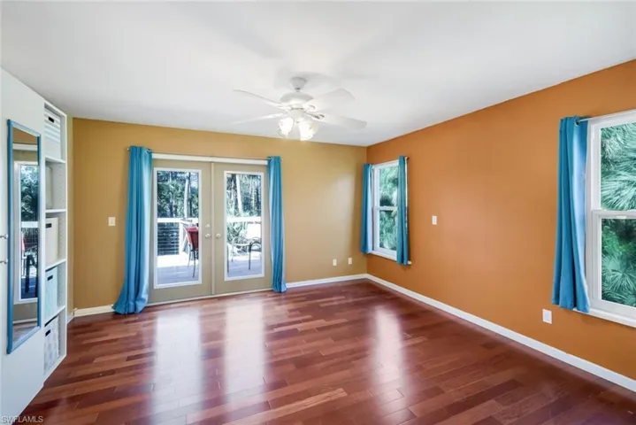 Unfurnished room with ceiling fan, hardwood / wood-style flooring, and french doors