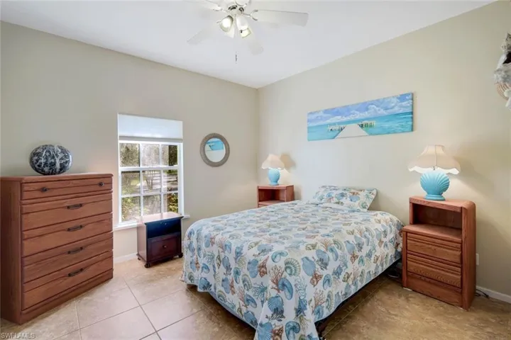 Bedroom with ceiling fan and light tile patterned flooring