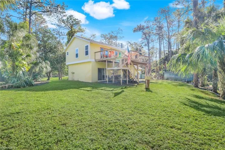 Back of house featuring a wooden deck and a yard