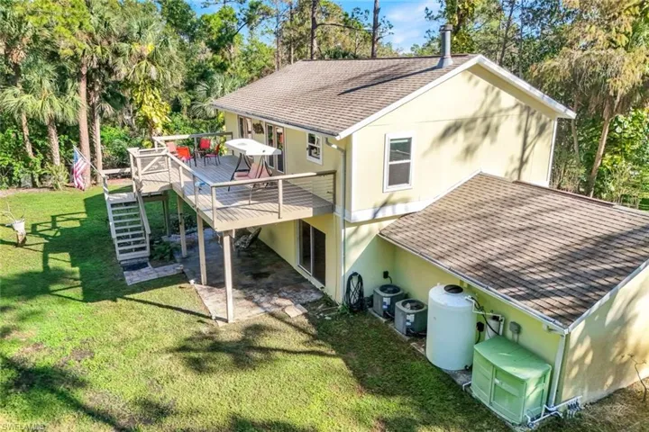 Rear view of property featuring a yard, a deck, and cooling unit