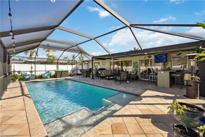View of swimming pool with a ceiling fan, a patio, an outdoor living space, fence, and a lanai