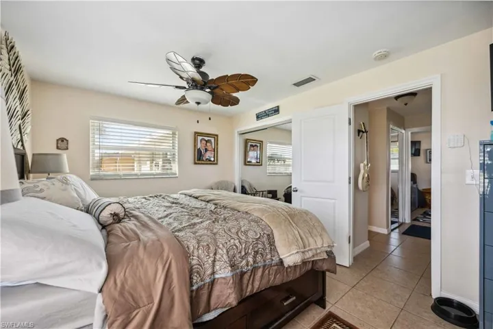 Bedroom with light tile patterned flooring, a ceiling fan, a closet, and baseboards