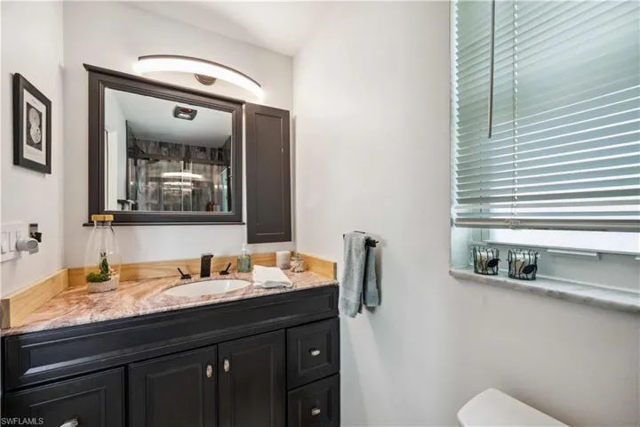 Bathroom featuring vanity, a stall shower, and toilet