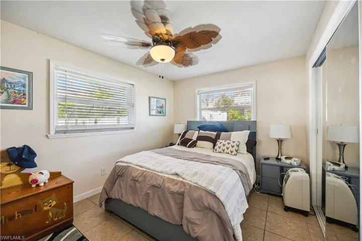 Bedroom featuring light tile patterned floors, a ceiling fan, and a closet