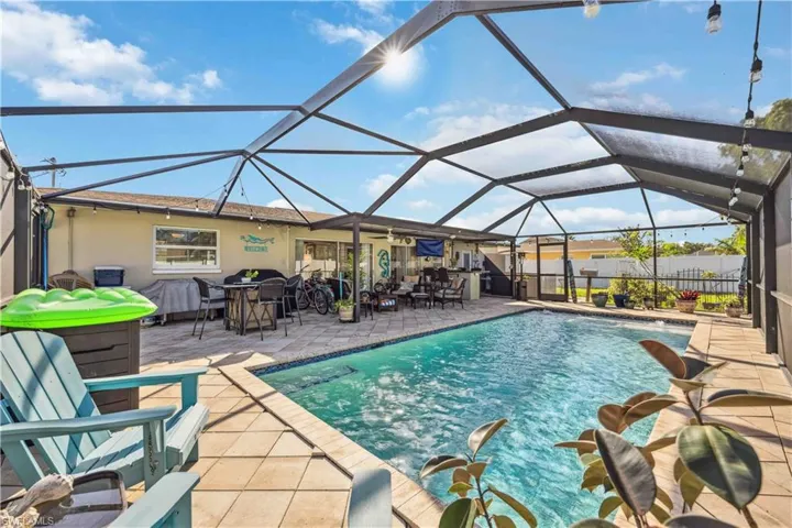 View of swimming pool with a patio, glass enclosure, ceiling fan, and fence