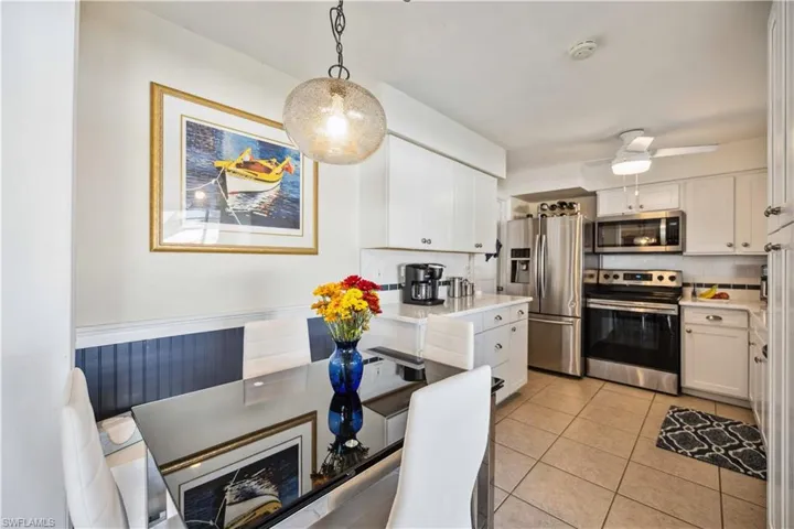Kitchen featuring stainless steel appliances, white cabinetry, light countertops, tasteful backsplash, and light tile patterned floors
