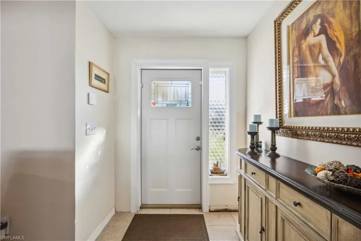 Foyer entrance featuring light tile patterned flooring and baseboards