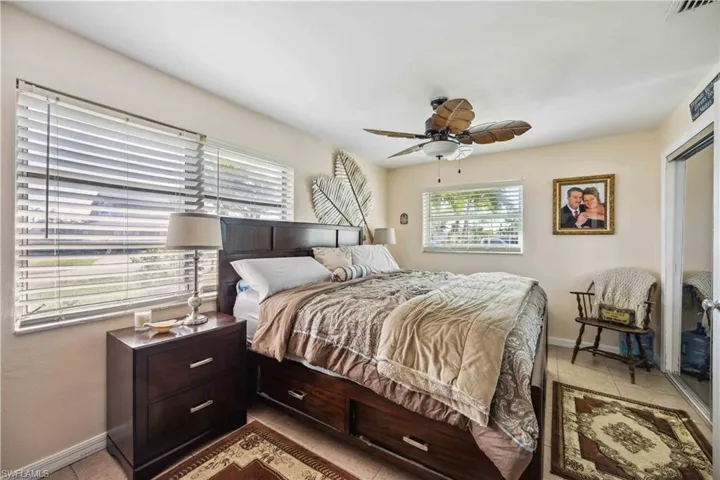 Bedroom with baseboards, light tile patterned floors, and a ceiling fan