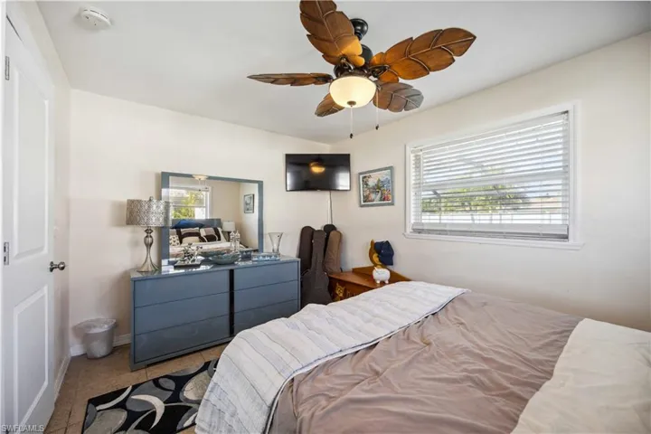 Bedroom with multiple windows, baseboards, and ceiling fan