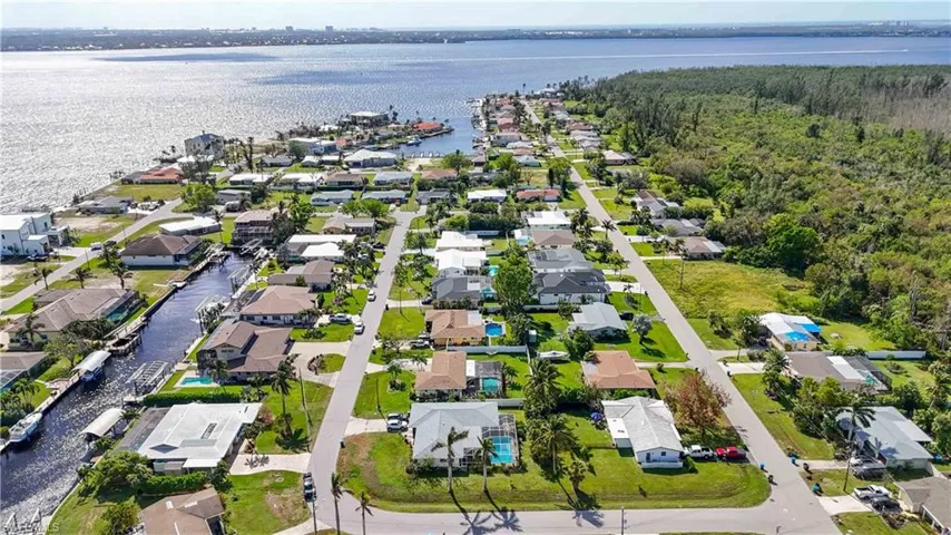 Aerial view of property's location featuring a nearby body of water and nearby suburban area