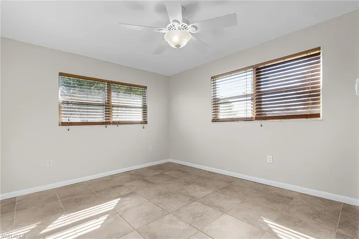 Unfurnished room with ceiling fan and light tile patterned floors
