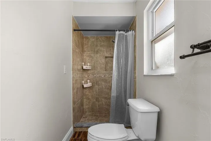 Full bath with toilet and a stall shower