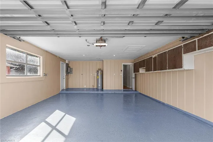 Garage with gas water heater and a garage door opener